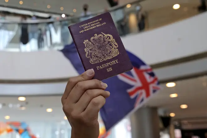Protesters hold a British National (Overseas) passport and Hong Kong colonial flag in a shopping mall during a protest against China's national security legislation for the city, in Hong Kong