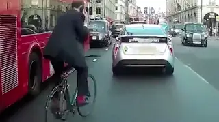 Reckless Cyclist Weaves Through London Traffic Whilst On Phone