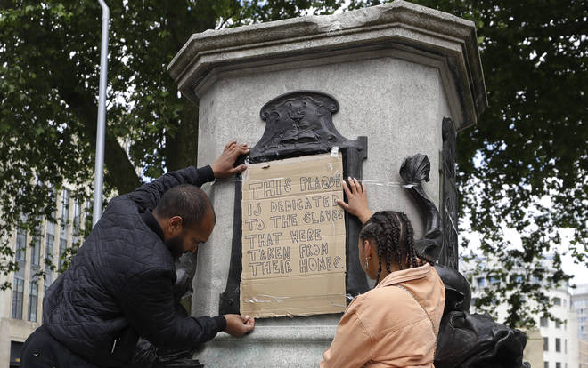 A hand-written sign has been placed where the statue stood
