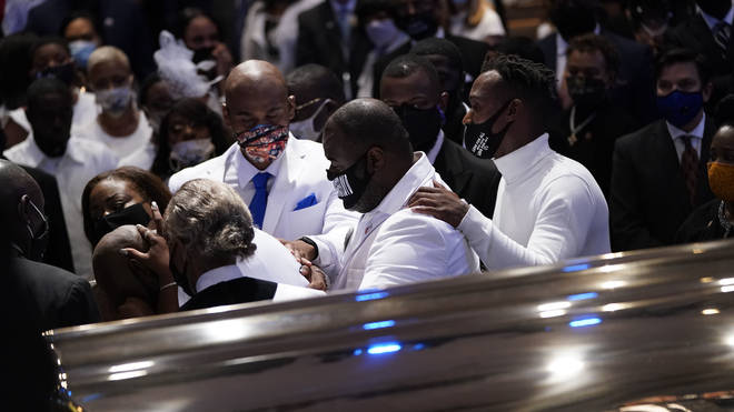 Family members grieve together at the funeral of George Floyd