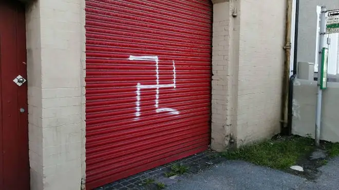 A man has been arrested after a swastika was painted on a black family's home