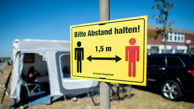 A sign at a German campsite reads "Please keep your distance"