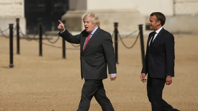 Prime Minister Boris Johnson and French president Emmanuel Macron walk together at Horse Guards Parade to watch the display