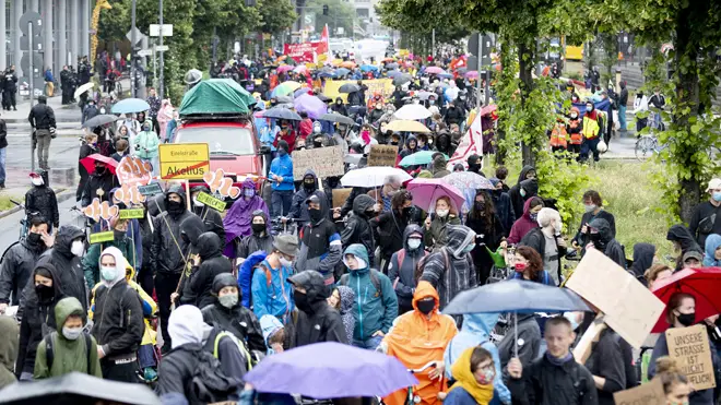 People in protective masks march at a protest in Berlin