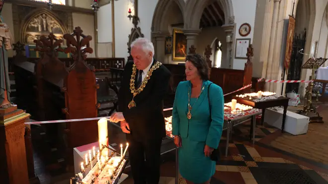 Wokingham Town Mayor Tony Lack and wife Claire light a candle in St Paul's Parish Church, Wokingham, for teacher James Furlong