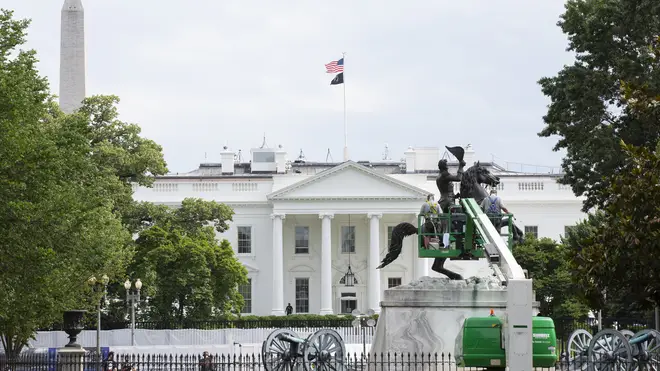 Workers clean the Andrew Jackson statue in Lafayette Square near the White House in Washington D.C