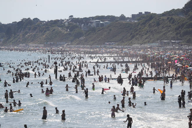 Swimmers take to the water off the beach in Bournemouth, Dorset, after the UK officially recorded its warmest day of the year
