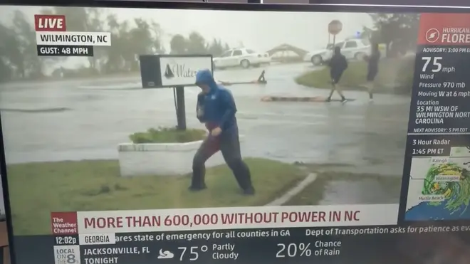 Two men appear to walk without problem behind the struggling reporter.