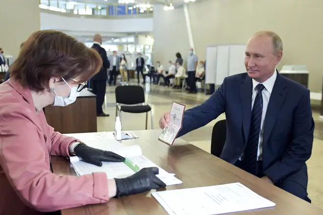 Mr Putin showed his passport to an election worker at the polling station