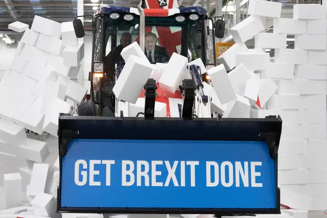 Boris Johnson bulldozing through a wall with the message 'Get Brexit Done'