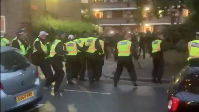 Police appeared to be pelted with bottles while dispersing a party in west London