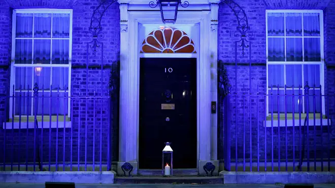 A candle is lit and placed on the doorstep of 10 Downing Street in central London