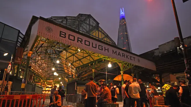 The Shard is lit blue in honour of the NHS as people are out in Borough Market, London