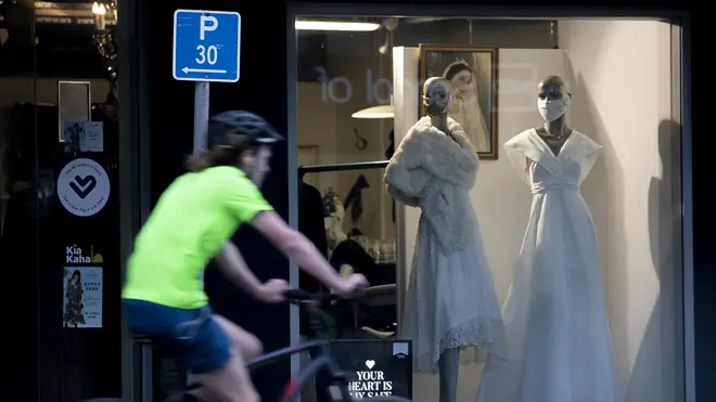 A cyclist passes mannequins in face masks in Christchurch