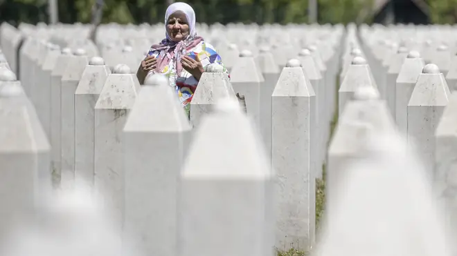 A woman prays at the memorial cemetery in Potocari, near Srebrenica, Bosnia