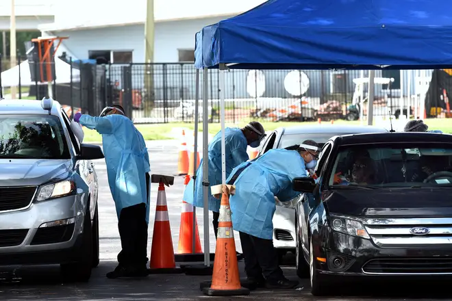 People are tested for COVID-19 at a drive through testing site in Orlando
