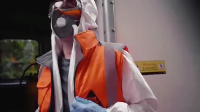 The artist is shown wearing PPE and a mask