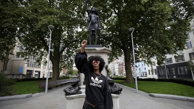 Jen Reid stands next to the new statue in Bristol