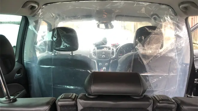 A non-approved covid-19 protective screen in a London private hire car