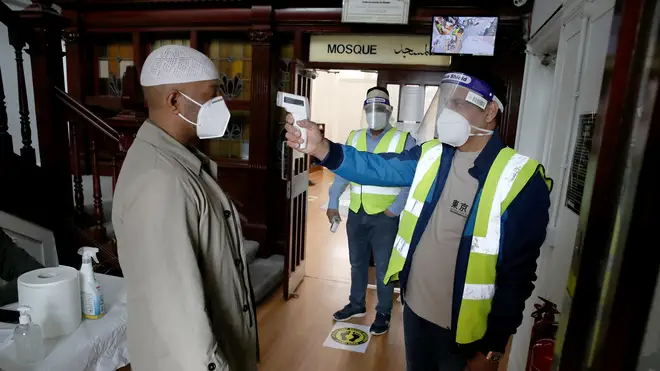 A worshipper has his temperature checked as he arrives for Friday sermon at the Baitur Rahman Mosque in Glasgow