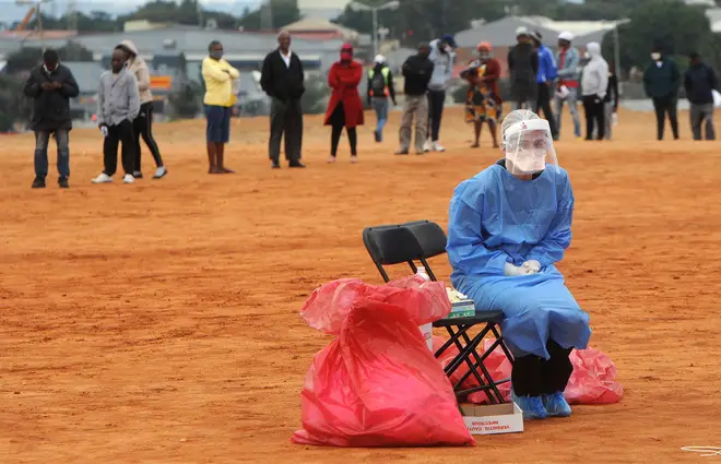 A medical practitioner waits for patients to test for COVID-19 in Alexandra township, Johannesburg