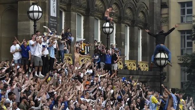 Leeds United fans celebrate after winning the Sky Bet Championship title at Millennium Square