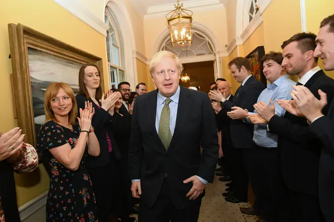 Prime Minister Boris Johnson is greeted by staff as he arrives back at 10 Downing Street in December