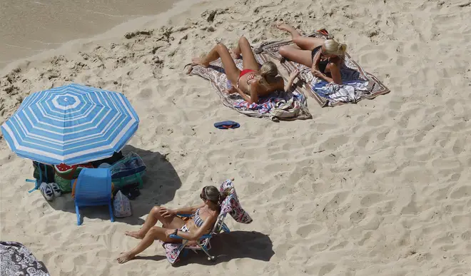 Three women relax on the beach in Spain