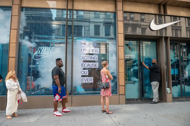 File photo: People with and without masks wait in the line outside the Nike store