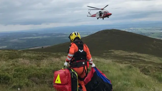 A Search and Rescue helicopter assisting a walker near Dumfries, Scotland
