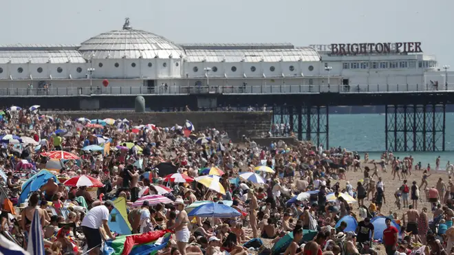 Beachgoers in Brighton enjoy the sunshine on what is now Britain's hottest day of the year so far
