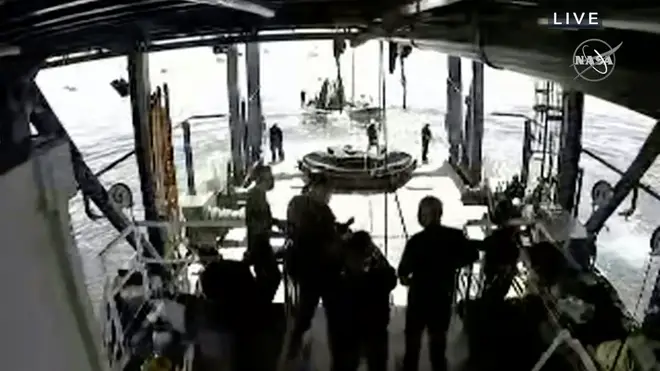 Crew wait for the recovery of Crew Dragon after its landing