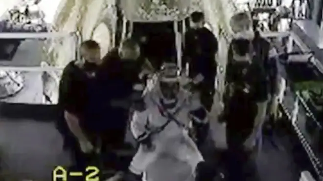 Doug Hurley waves as he is assisted out of the SpaceX capsule
