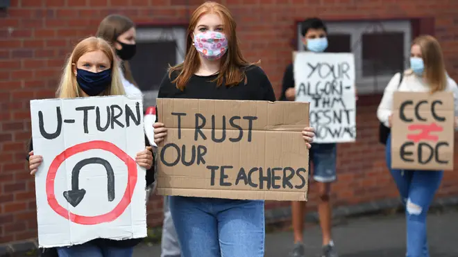 Students hold placards calling for a u-turn over their A-level results