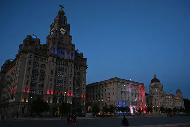 The Royal Liver Building (L) lit up by red, white and blue lights to commemorate the 75th anniversary of VE Day