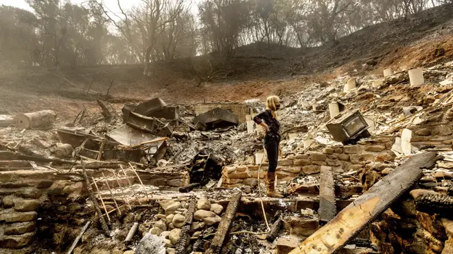 A woman surveys the remains of her partner's property in California