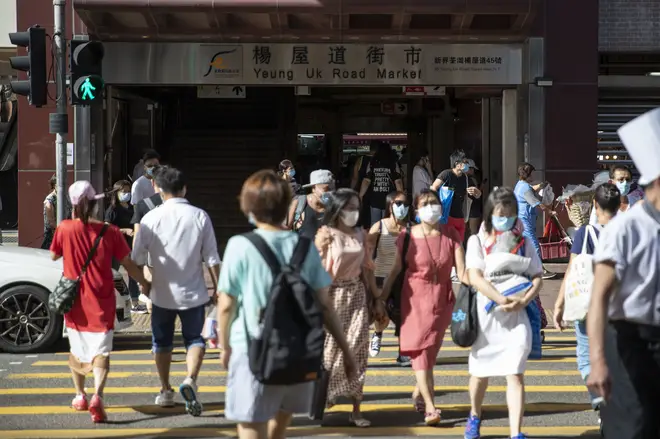 Pedestrians walk across the road while wearing face masks as a preventive measure against the spread of Coronavirus in Hong Kong