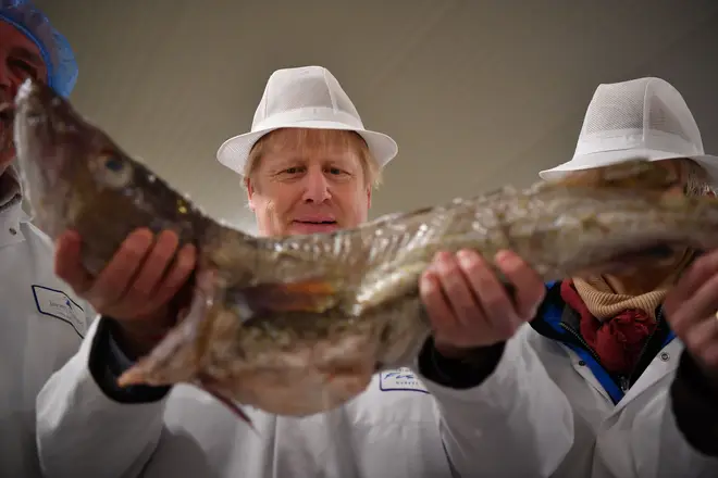 Boris Johnson holding a cod during an election campaign visit to Grimsby Fish Market last December