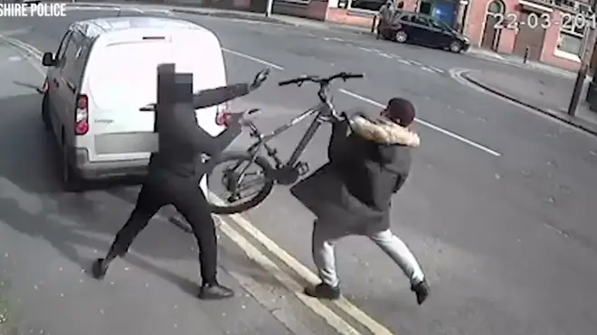 The cyclist throws his bike at the attacker in an attempt to escape