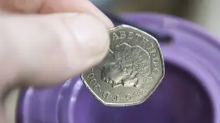 A donor puts 50p in a charity box