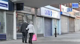 People walking past closed shops