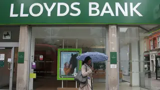 A woman walks past a branch of Lloyds Bank