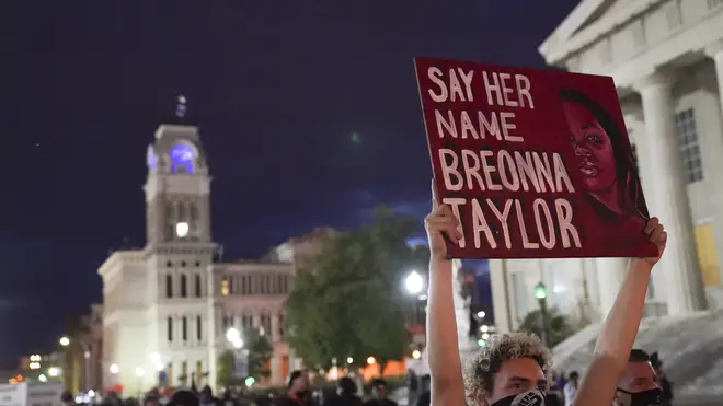 A protester holds up a 'say her name Breonna Taylor' sign during a march in Louisville