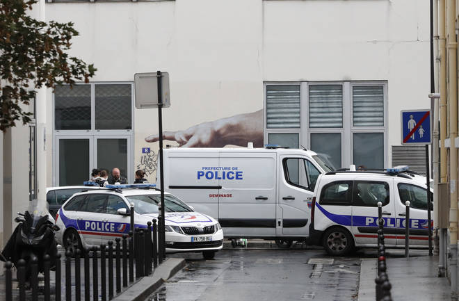 Police vehicles park outside a building after four people have been wounded in a knife attack near the former offices of satirical newspaper Charlie Hebdo