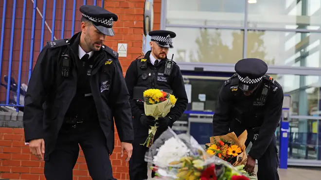 Police officers leave flowers outside Croydon Custody Centre in south London