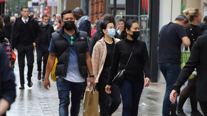 File photo: People walk along Oxford Street while wearing face masks as a preventive measure against the spread of Coronavirus