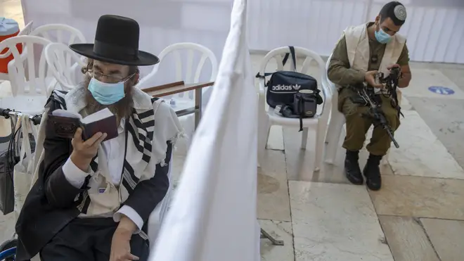 An ultra-Orthodox Jewish man and an Israeli soldier pray ahead of Yom Kippur in Jerusalem