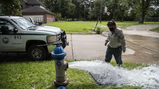 Kristina Watson, a Lake Jackson water waste operator, flushes water out from a fire hydrant