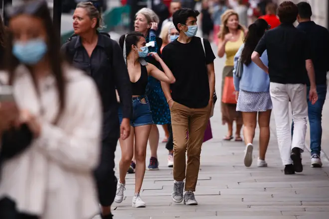 Shoppers, some wearing face masks, walk along Regent Street in London
