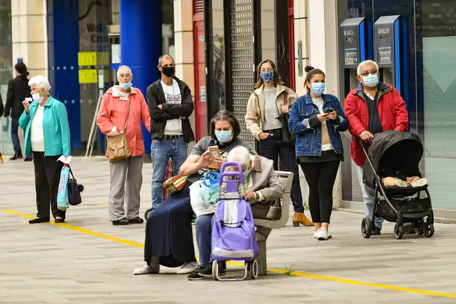 File photo: People wear face coverings as they queue for shops and businesses in Cardiff